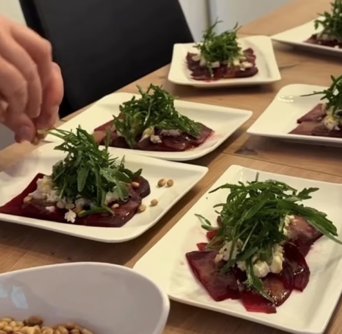Angerichtete Teller mit Rote-Bete-Carpaccio, Rucola und Pinienkernen aus einem Kochworkshop